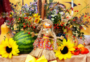 Foto von Herbstdekor und einer handgefertigten Nationalpuppe mit Blättern, Wassermelonen, Blumen und Ernte